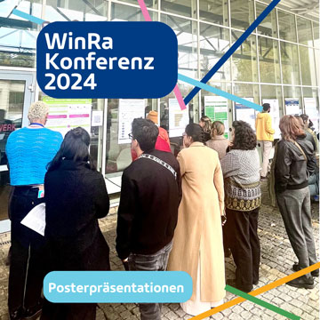 Teilnehmende der Konferenz sehen sich die Posterausstellung an.